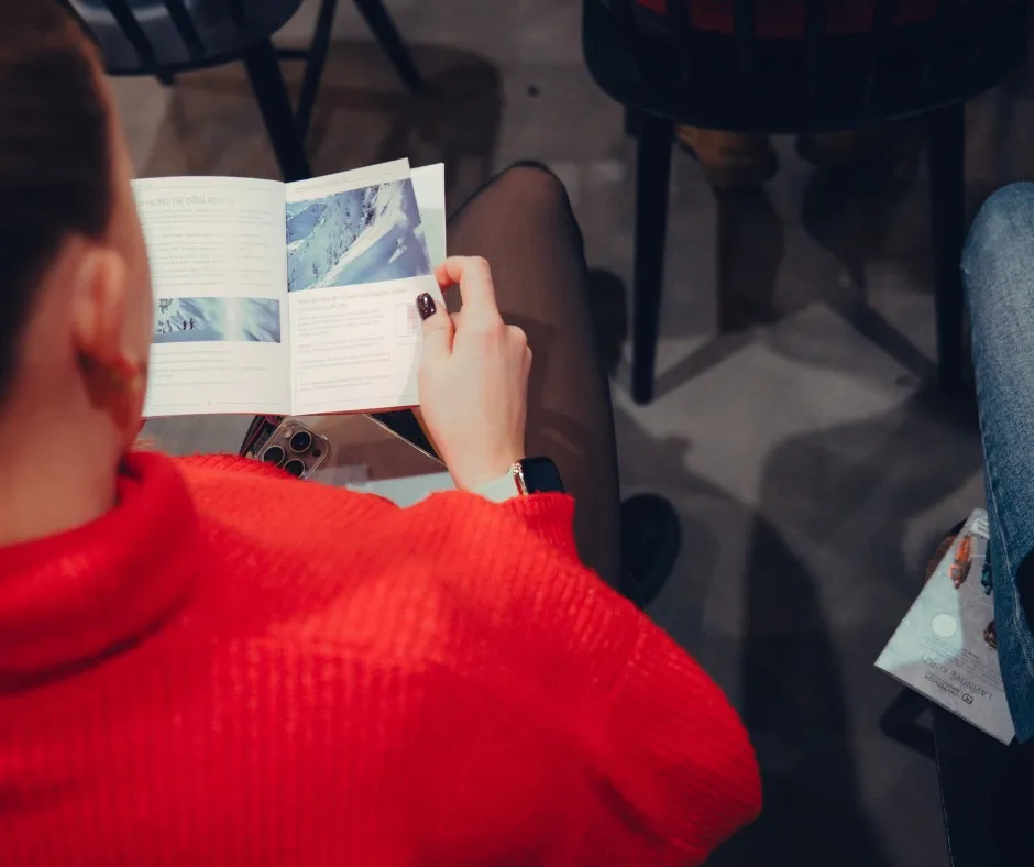 open magazine, reading, red sweater, booklet, brochure