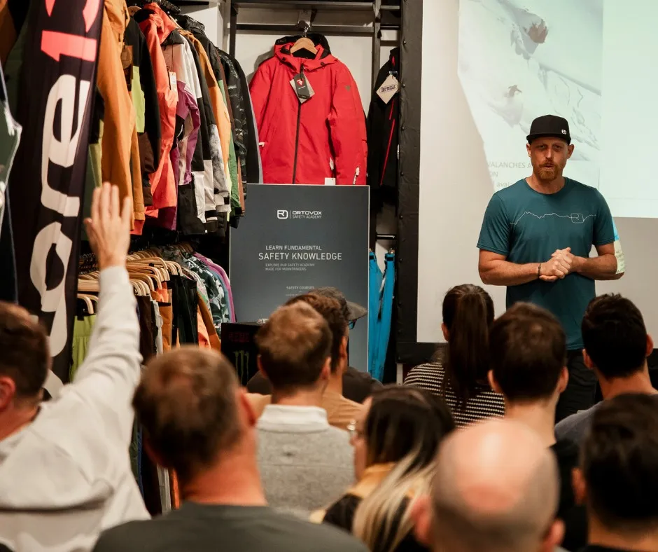 outdoor jacket, clothing store, presentation, speaking instructor, audience