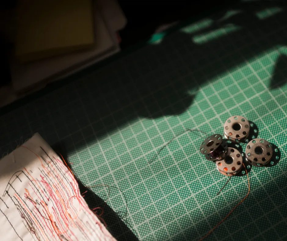 spools, thread, sewing, button, green mat